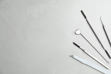 Set of different dentist's tools on light grey table, flat lay. Space for text