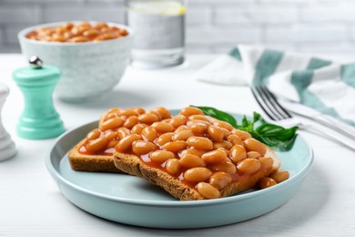 Photo of Toasts with delicious canned beans on white wooden table