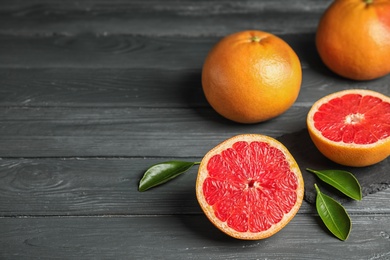 Photo of Fresh tasty grapefruits on table. Space for text