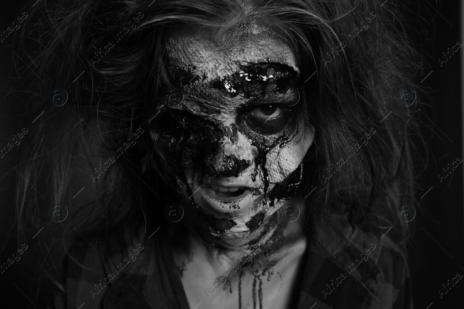 Photo of Scary zombie on dark background, black and white effect. Halloween monster