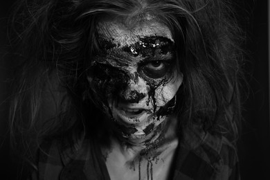 Scary zombie on dark background, black and white effect. Halloween monster