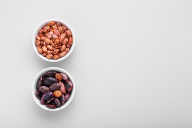 Photo of Different kinds of kidney beans on white background, top view. Space for text