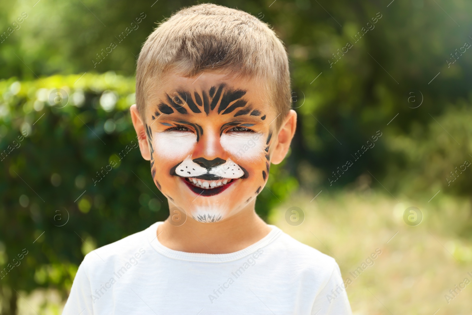 Photo of Cute little boy with face painting outdoors