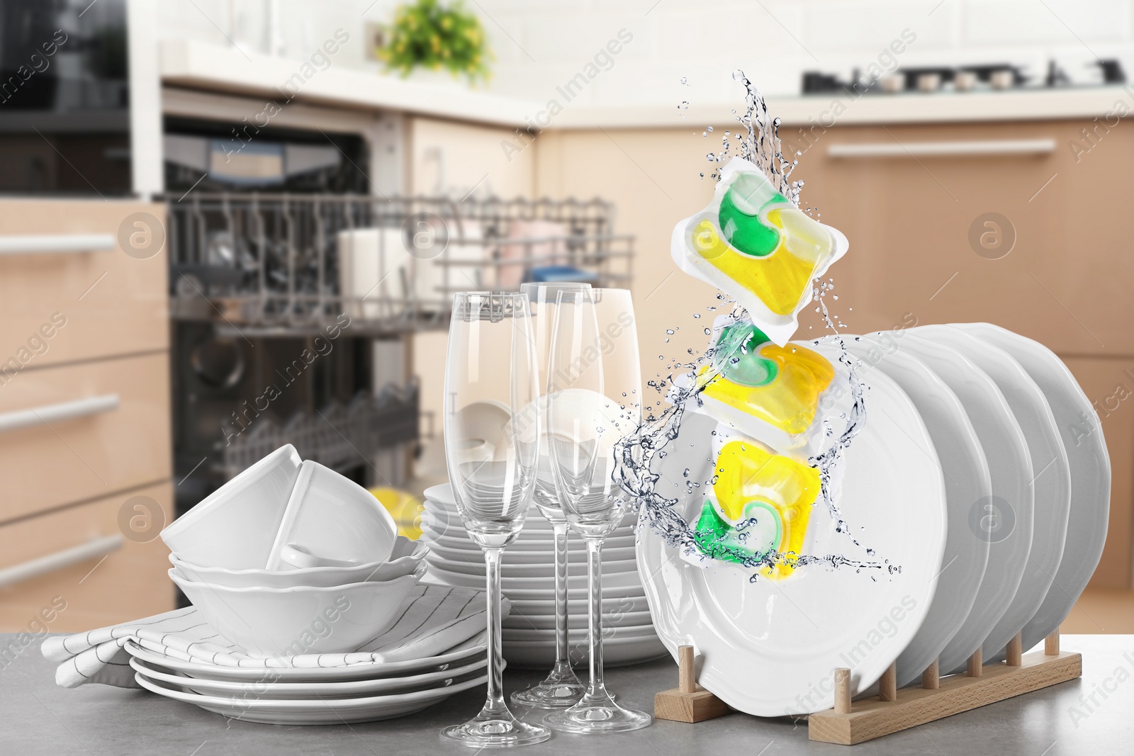 Image of Many clean tableware in kitchen. Dishwasher detergents falling with water splashes