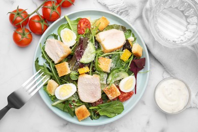 Photo of Delicious salad with croutons, chicken and eggs served on white marble table, flat lay