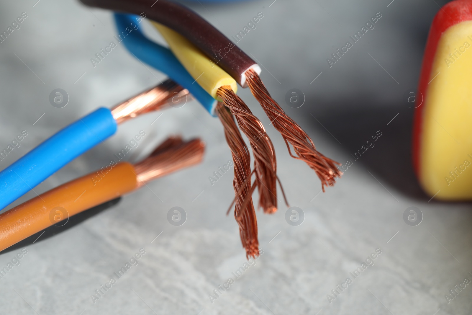 Photo of Colorful electrical wires on gray surface, closeup