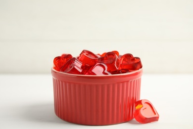 Photo of Tasty heart shaped jelly candies on white table