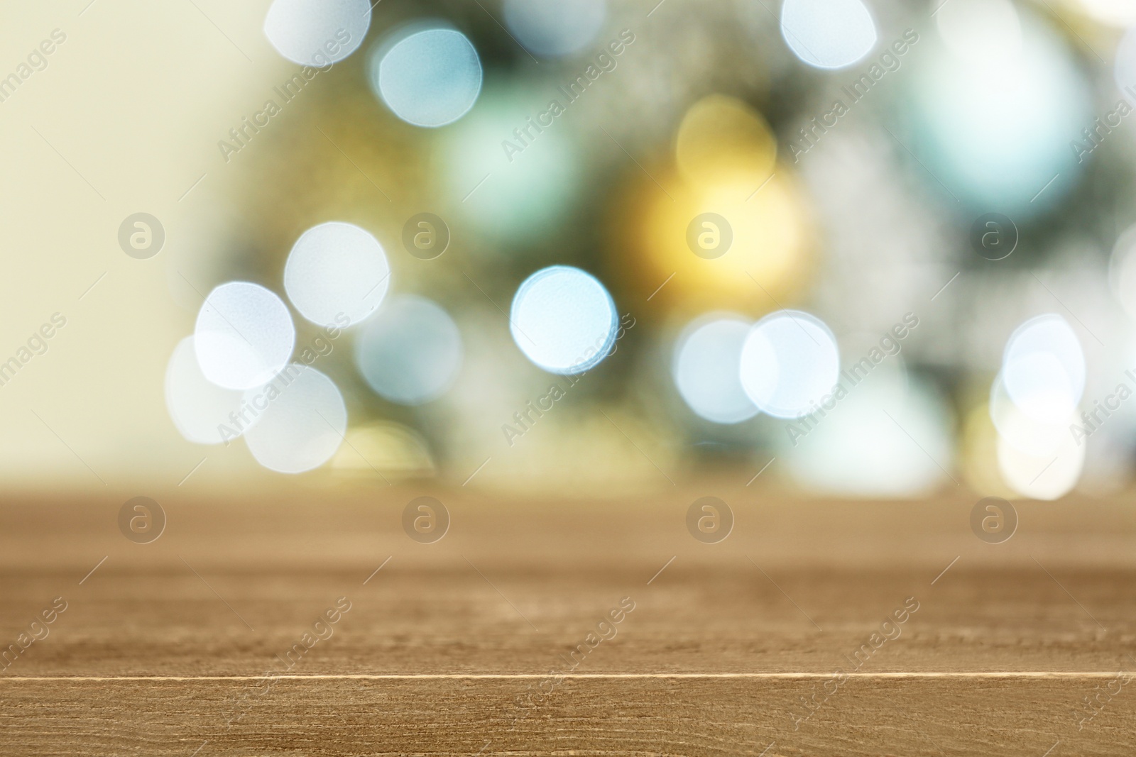 Photo of Empty wooden table and blurred fir tree with Christmas lights on background, bokeh effect. Space for design