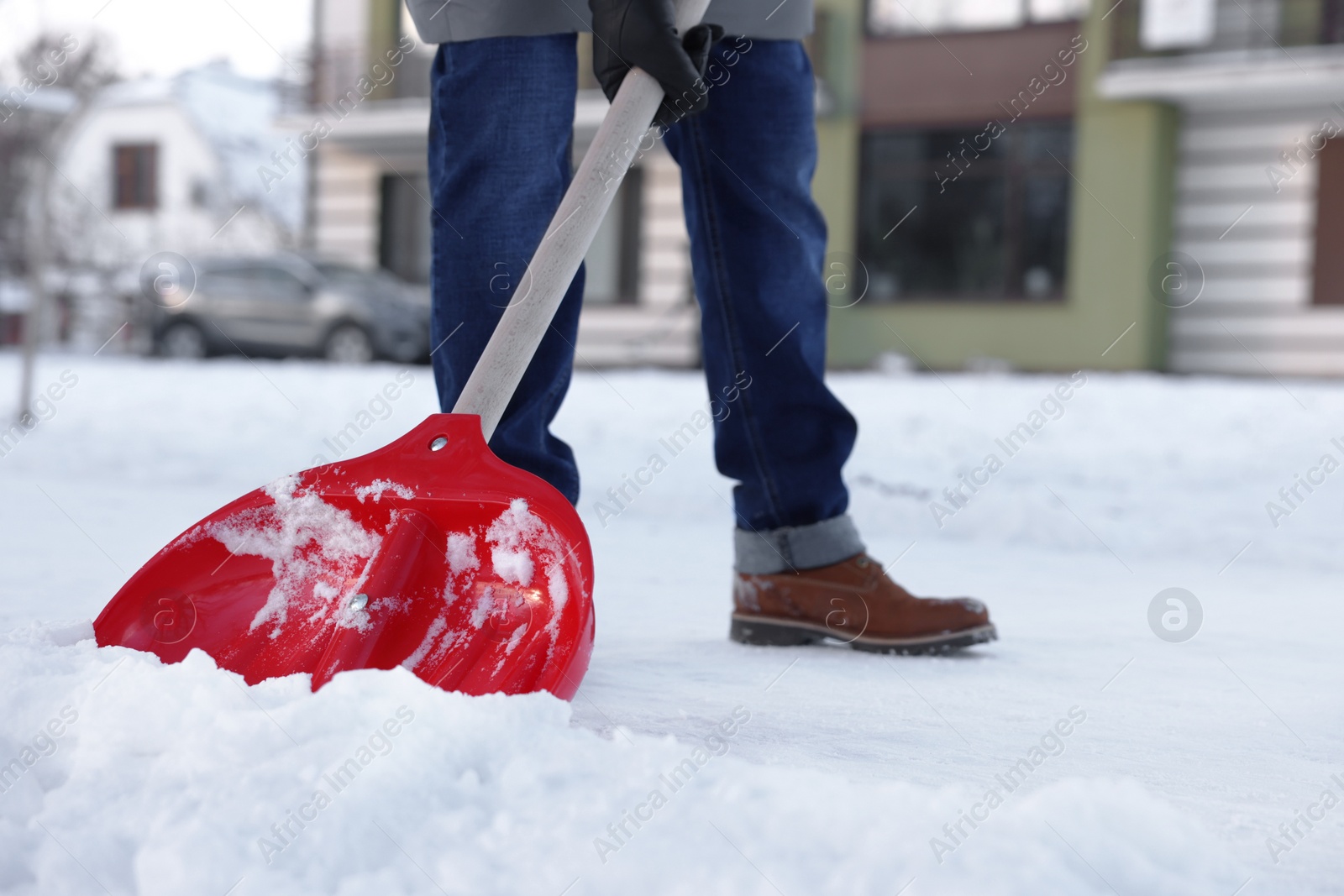 Photo of Man shoveling snow on city street, closeup