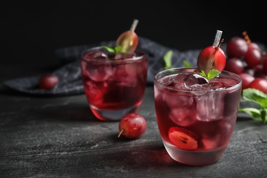 Photo of Delicious grape soda water on black table. Refreshing drink