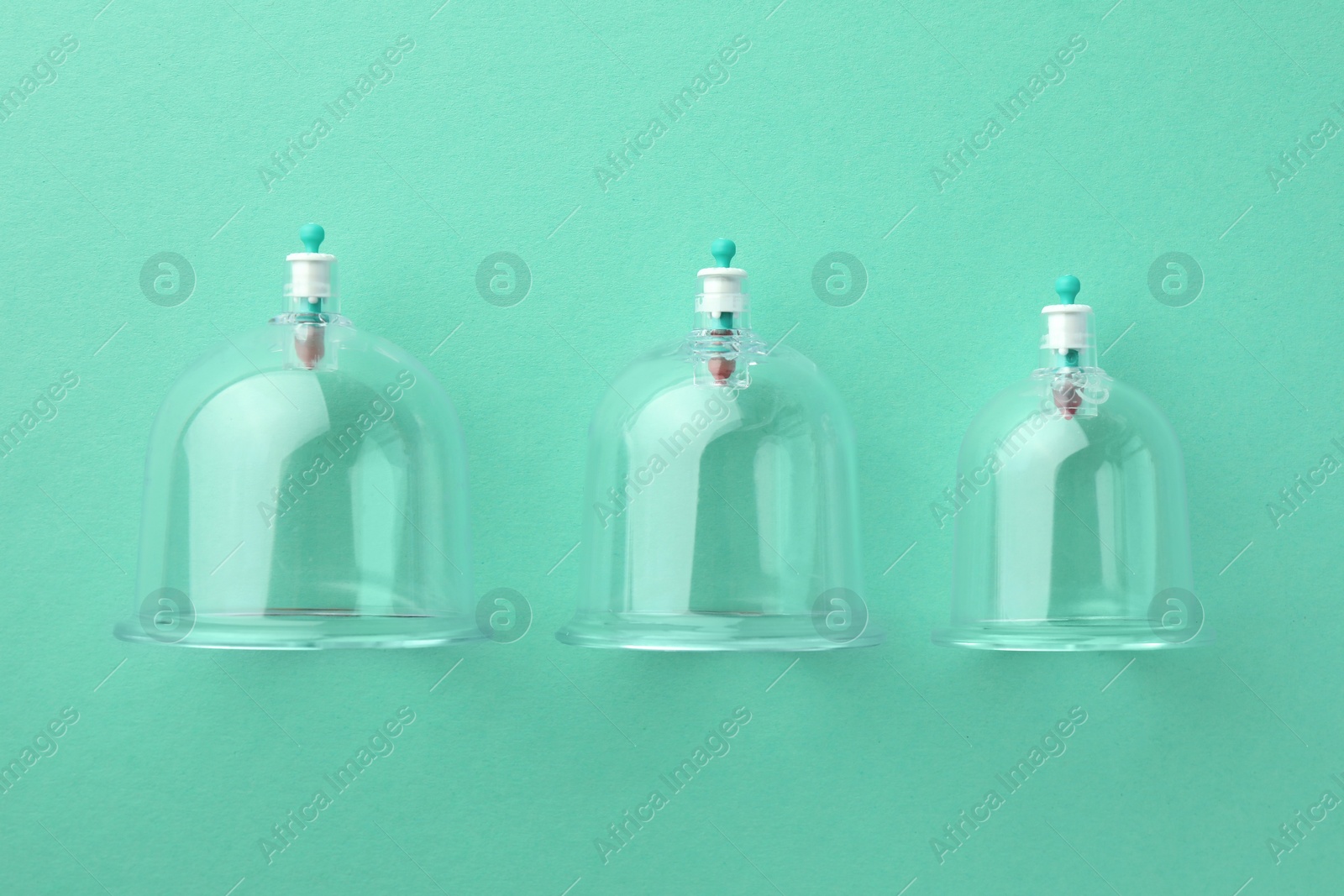 Photo of Plastic cups on turquoise background, flat lay. Cupping therapy