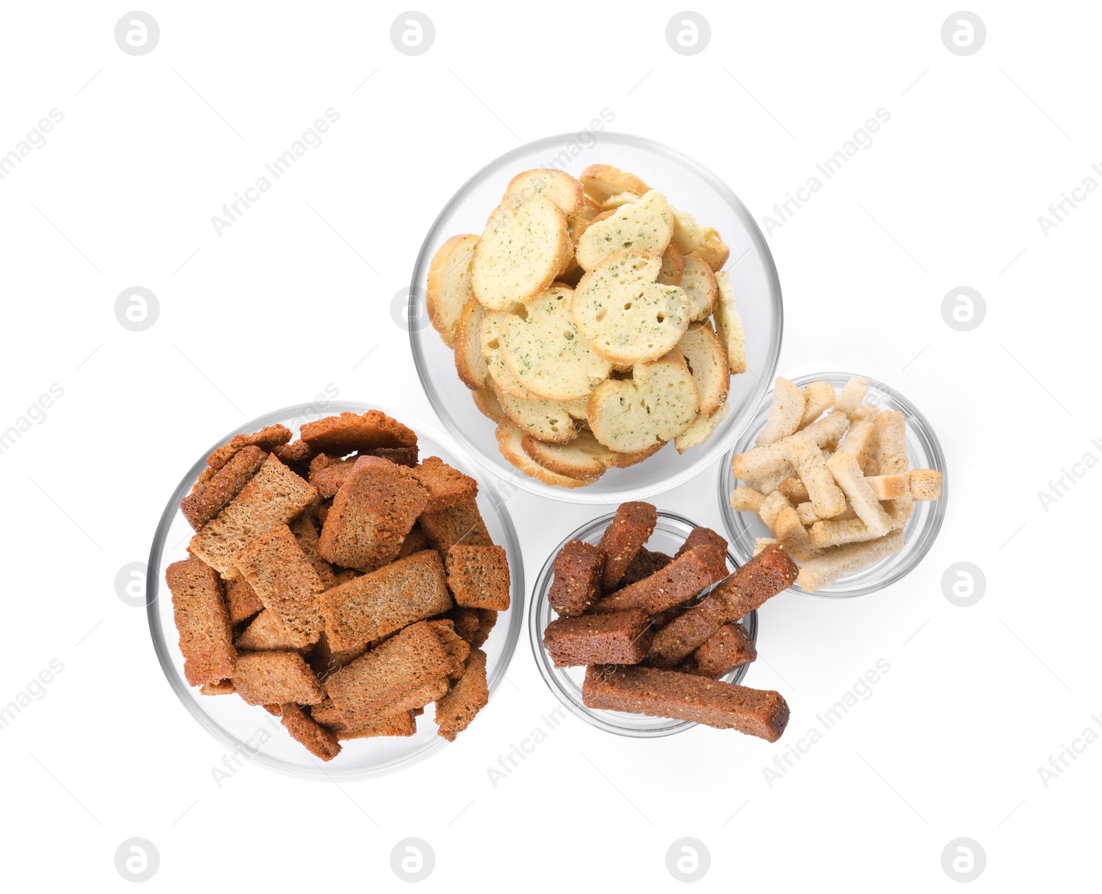 Photo of Different crispy rusks in bowls on white background, top view