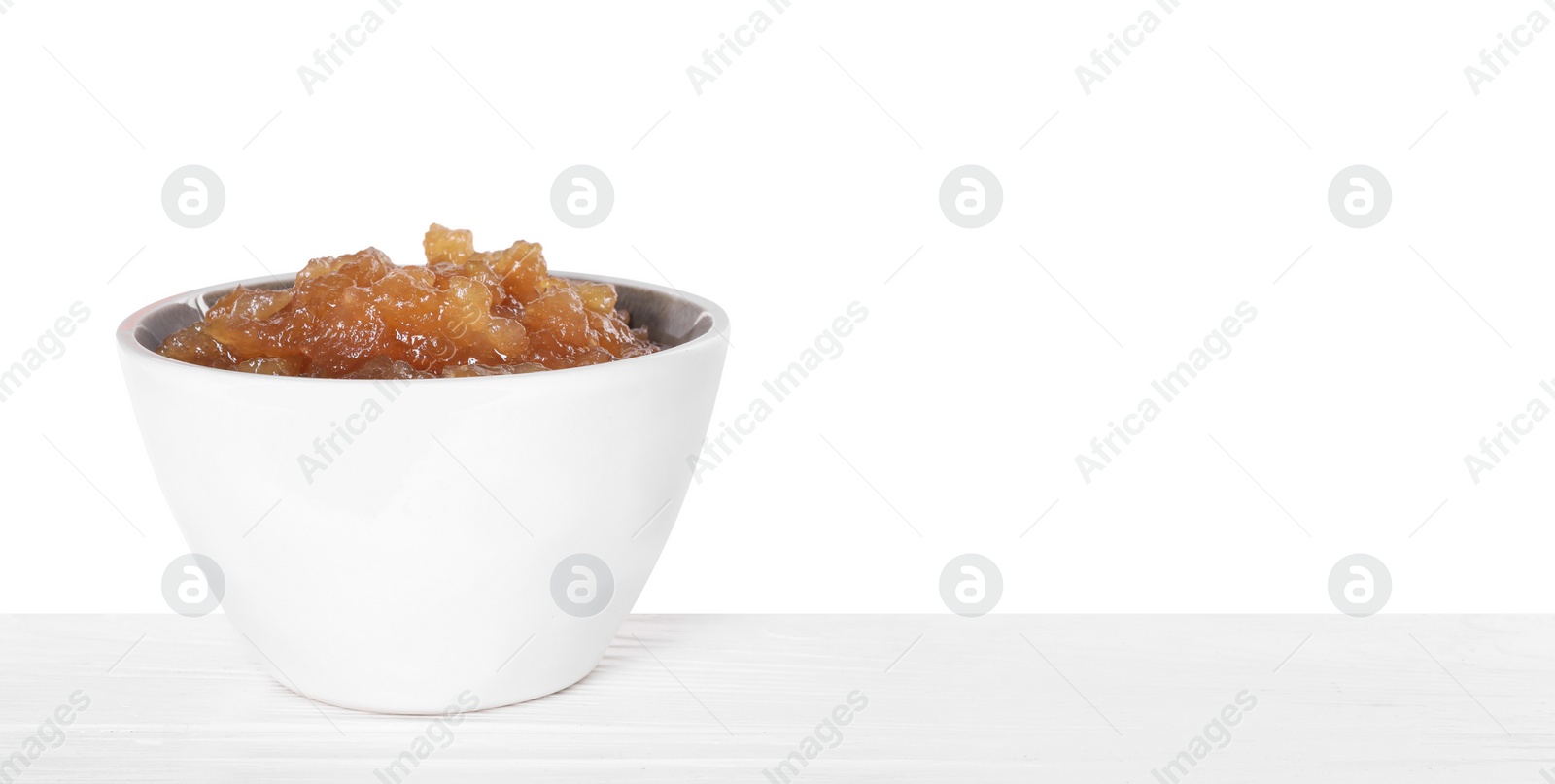 Photo of Delicious apple jam in bowl on wooden table against white background, space for text