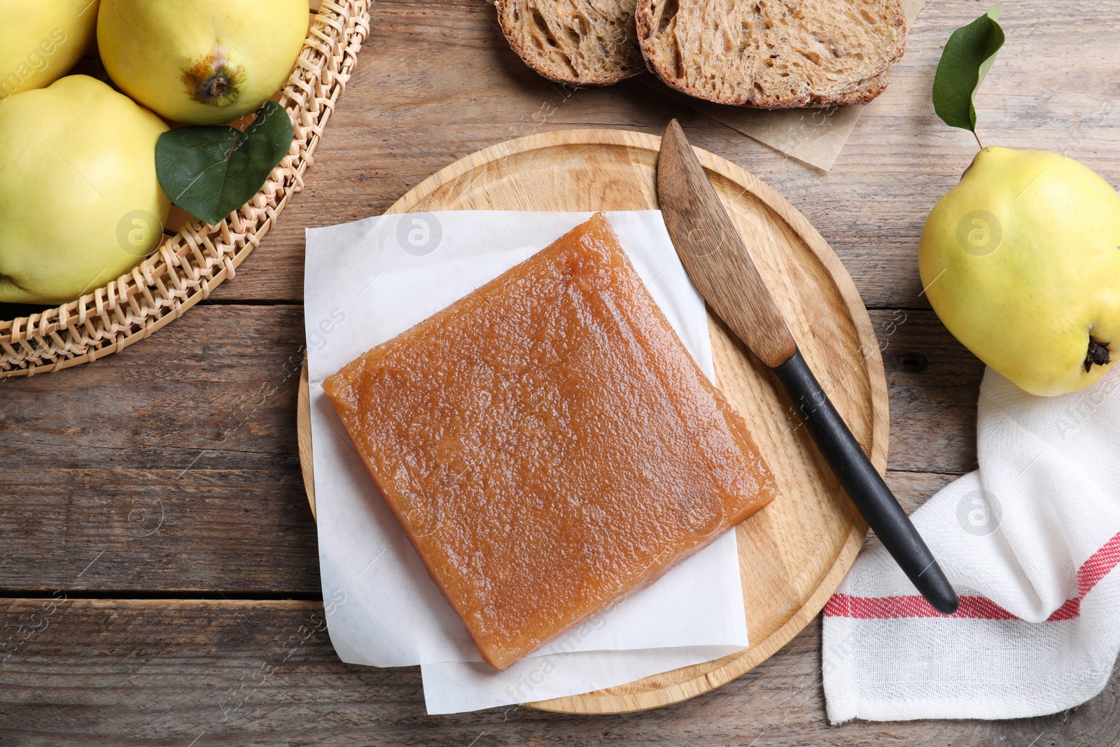 Photo of Delicious quince paste and fresh fruits on wooden table, flat lay