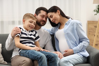 Photo of Pregnant woman spending time with her son and husband at home
