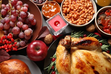 Photo of Traditional Thanksgiving day feast with delicious cooked turkey and other seasonal dishes served on table, top view