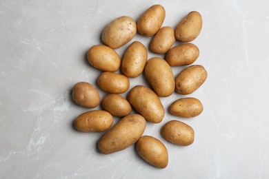 Fresh ripe organic potatoes on grey background, top view