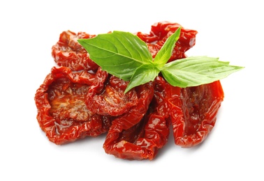 Photo of Tasty sun dried tomatoes with green leaves on white background