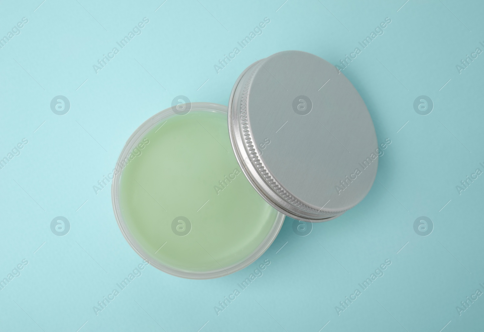 Photo of Jar of petroleum jelly on light blue background, top view