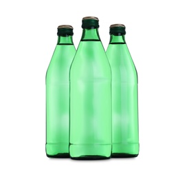 Glass bottles with water on table against white background
