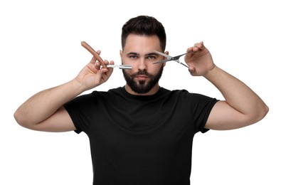 Handsome young man with mustache holding blade and scissors on white background