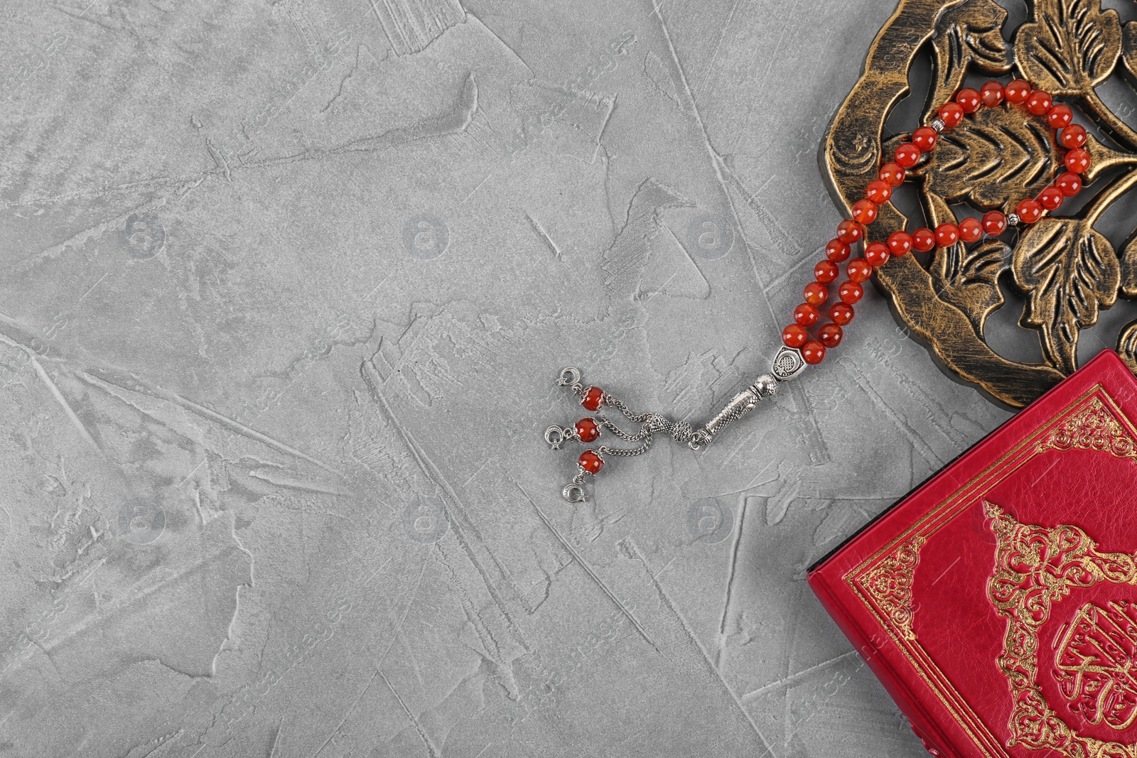 Photo of Flat lay composition with Muslim prayer beads, Quran and space for text on grey background