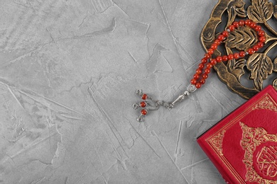 Photo of Flat lay composition with Muslim prayer beads, Quran and space for text on grey background