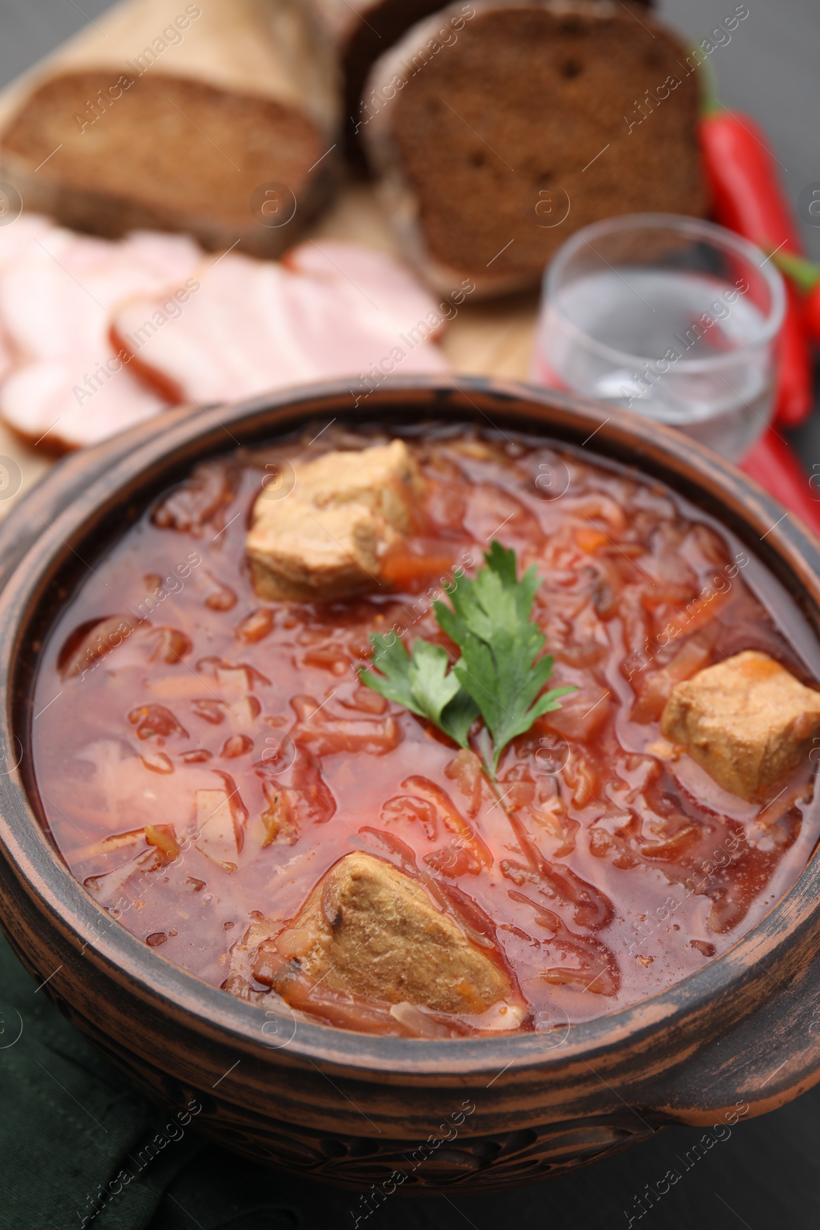 Photo of Tasty borscht in bowl on table, closeup