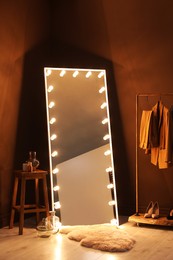 Photo of Stylish mirror with light bulbs in dressing room. Interior design