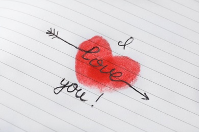 Text I Love You and red heart drawn on striped page