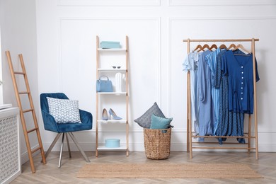 Photo of Dressing room with stylish clothes and shoes. Elegant interior design