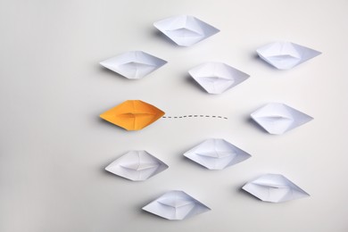 Photo of Yellow paper boat among others on white background, flat lay. Uniqueness concept