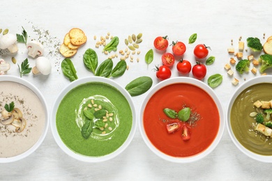 Flat lay composition with various soups and ingredients on white background. Healthy food