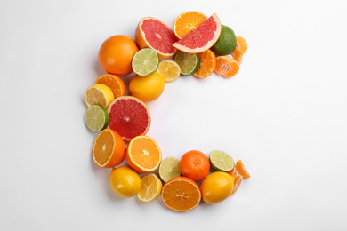 Photo of Letter C made with citrus fruits on white background as vitamin representation, top view