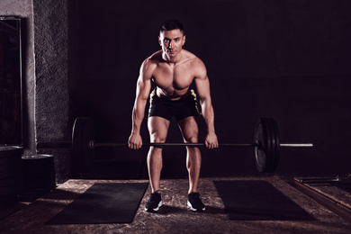 Photo of Strong man lifting barbell in modern gym