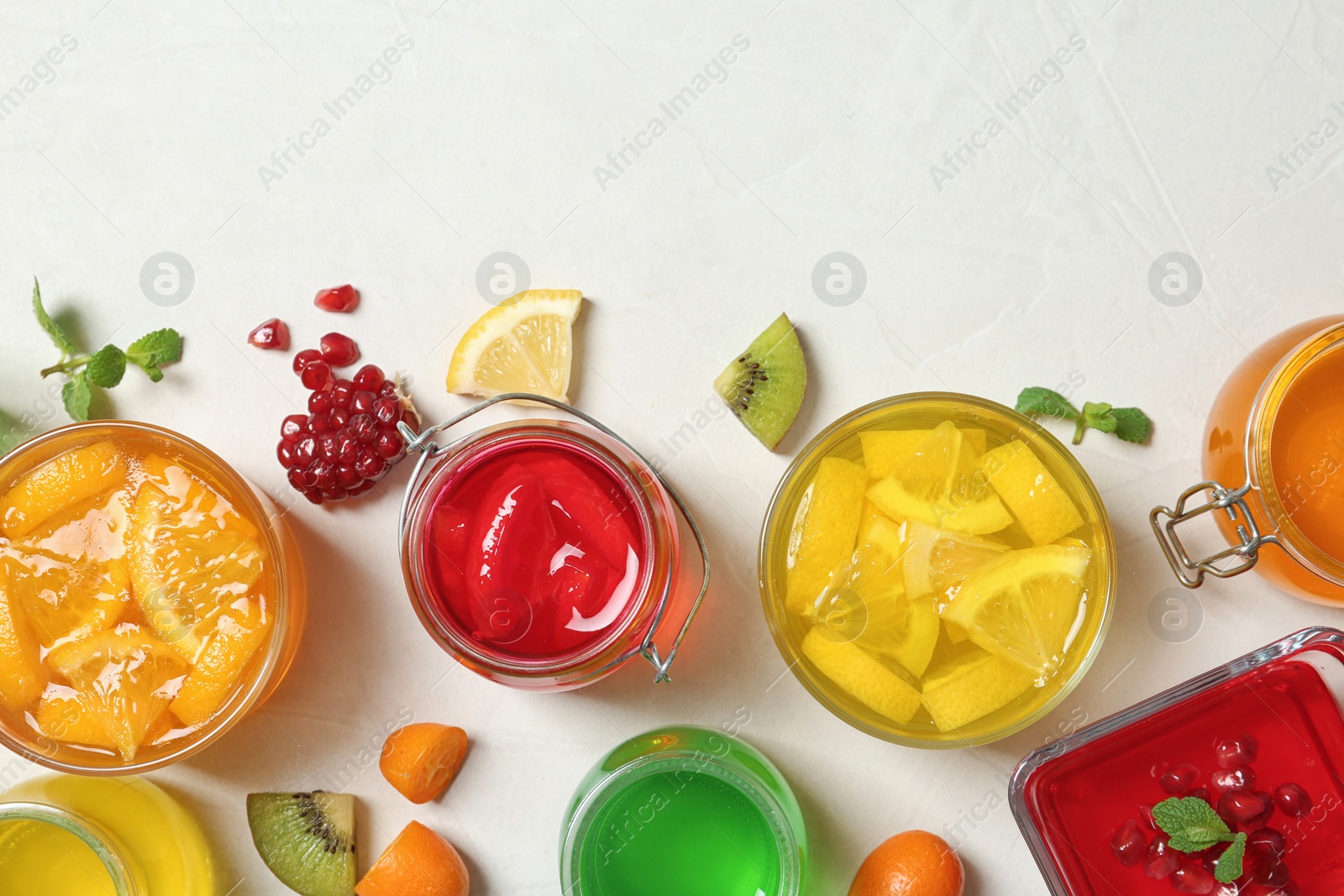 Photo of Flat lay composition with different jelly desserts on light background