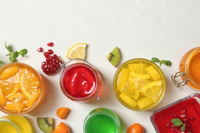 Flat lay composition with different jelly desserts on light background