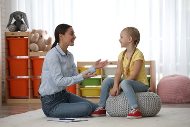 Child psychotherapist working with little girl in office