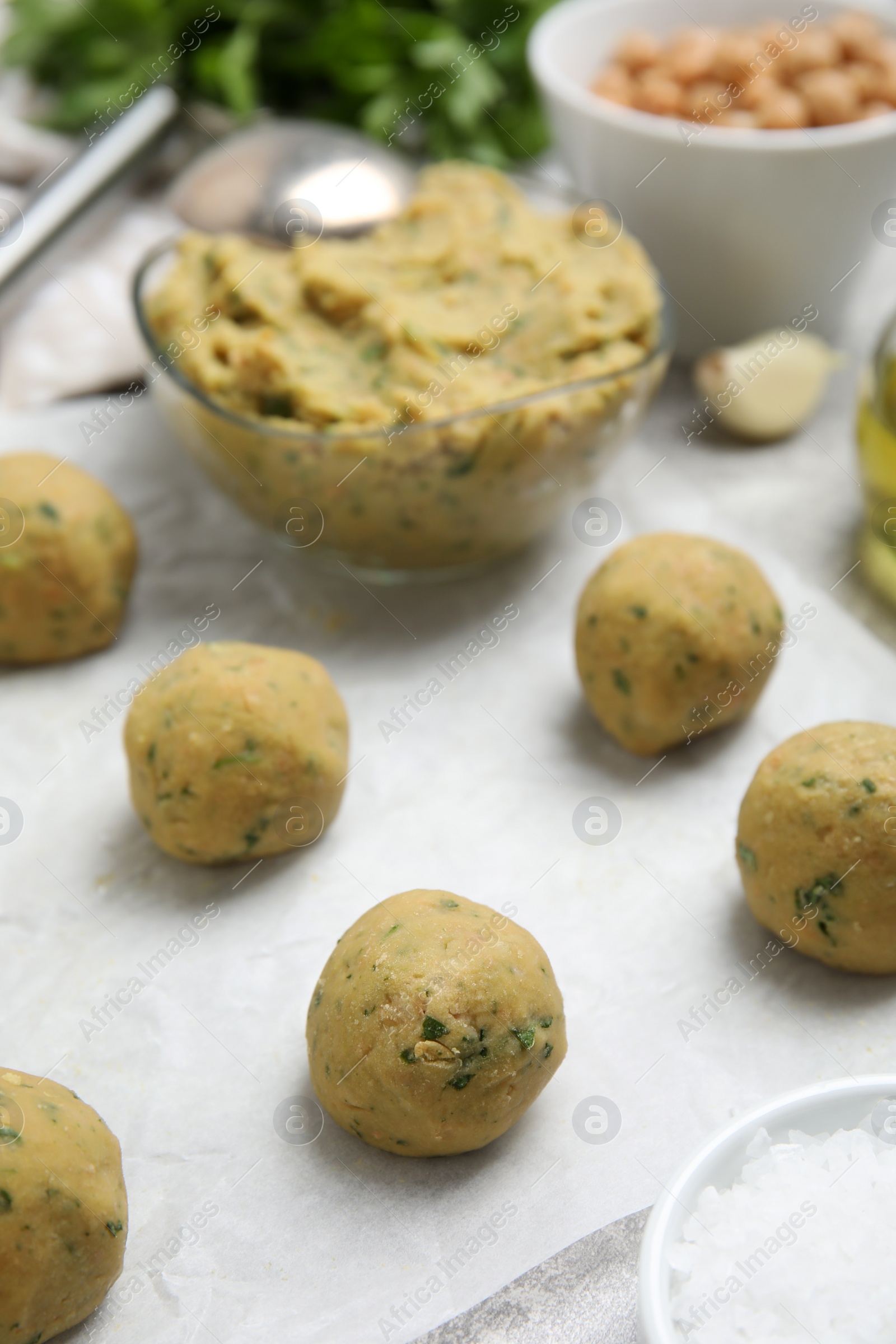 Photo of Raw falafel balls on grey table, closeup