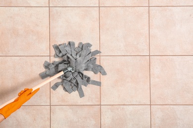 Photo of Janitor cleaning floor with mop, top view. Space for text