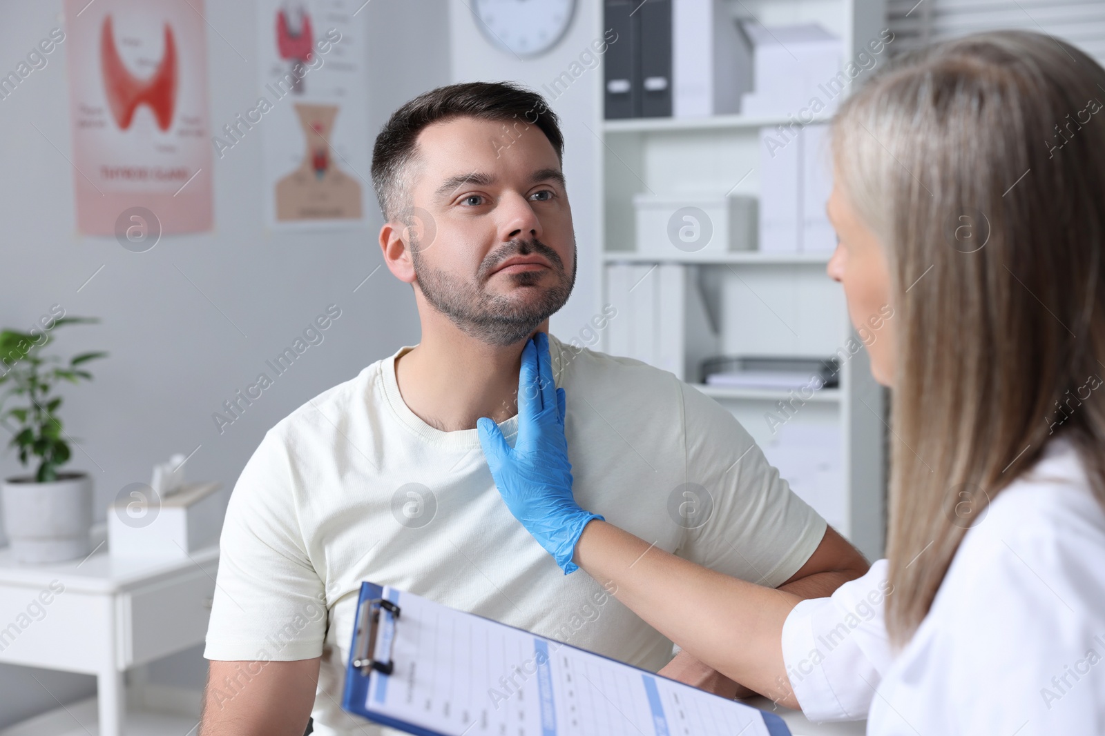 Photo of Endocrinologist examining thyroid gland of patient at hospital