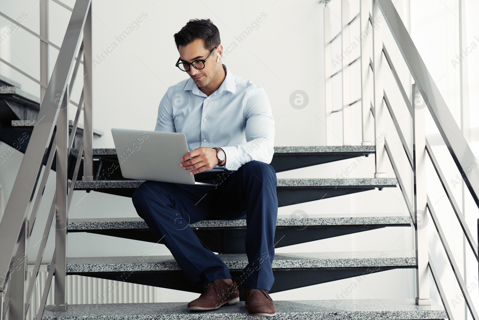 Photo of Portrait of young man with laptop indoors