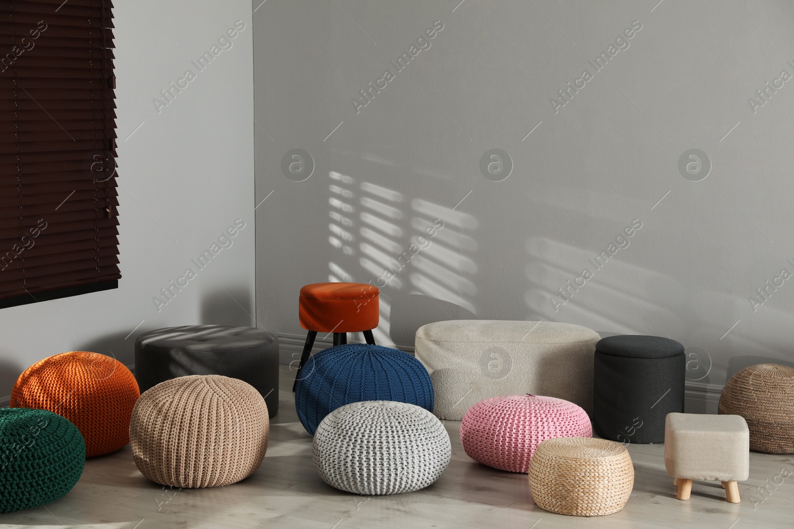 Photo of Many stylish different poufs in room. Home design