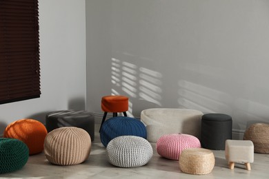 Many stylish different poufs in room. Home design