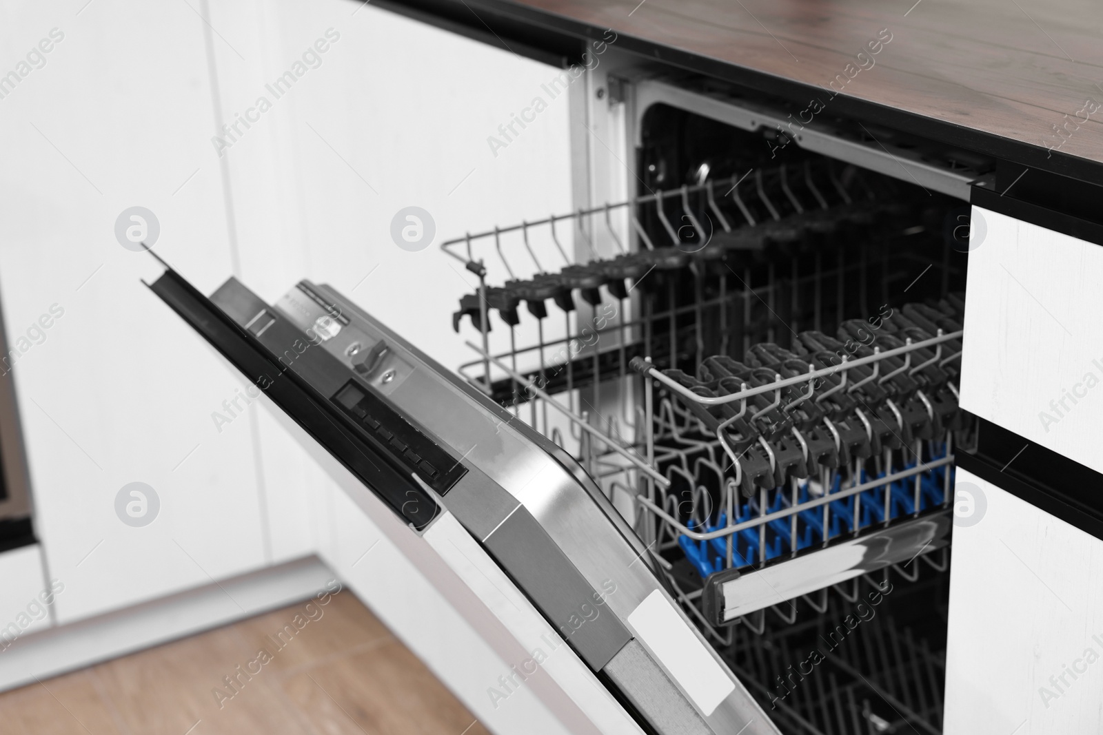 Photo of Built-in dishwasher with open door indoors. Home appliance