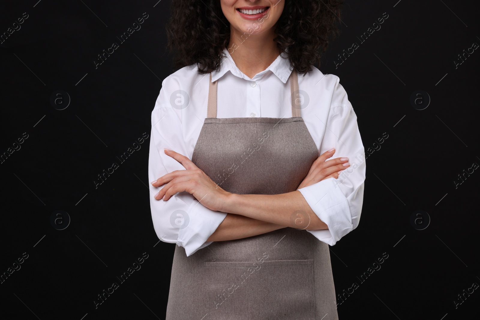 Photo of Woman wearing kitchen apron on black background, closeup. Mockup for design