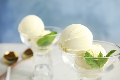 Photo of Delicious vanilla ice cream with mint served on table, closeup