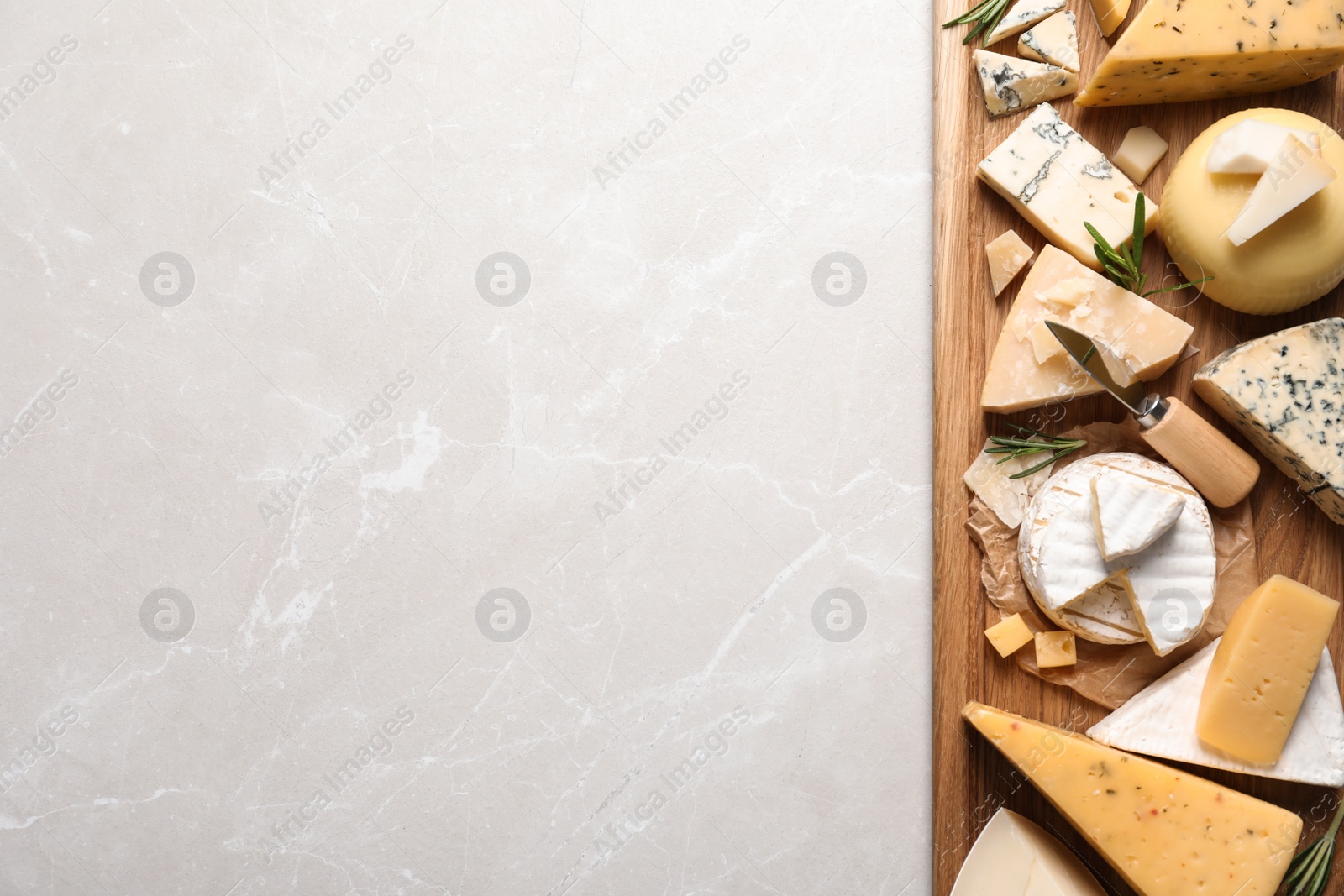 Photo of Different delicious cheeses served on grey table, top view. Space for text