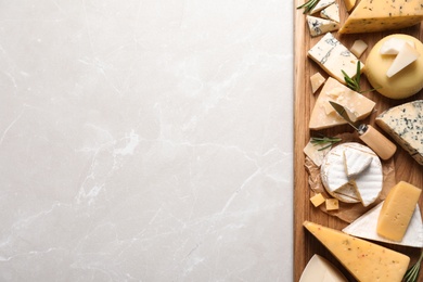 Different delicious cheeses served on grey table, top view. Space for text