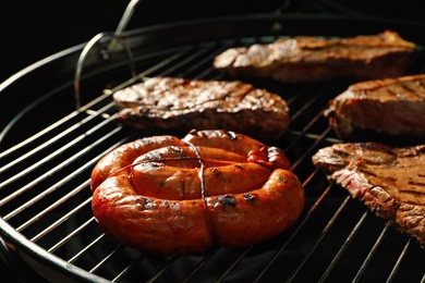 Fresh grilled tasty meat steaks and sausage on barbecue grate